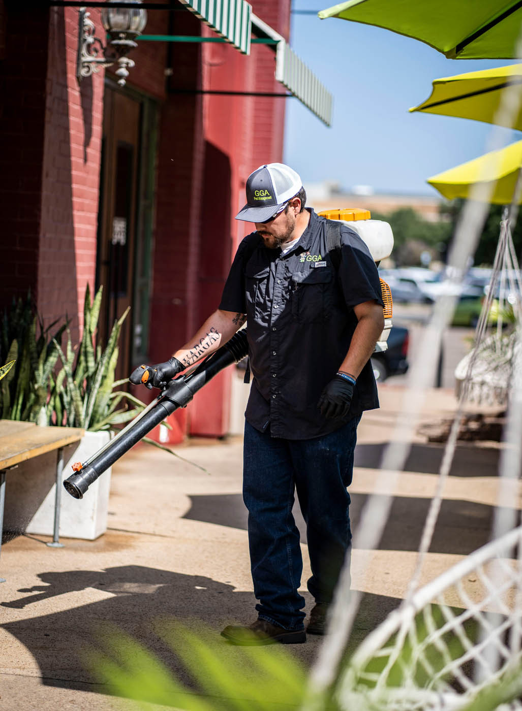 A fran_brand_name} professional spraying a yard for mosquito pest control in Temple, TX.