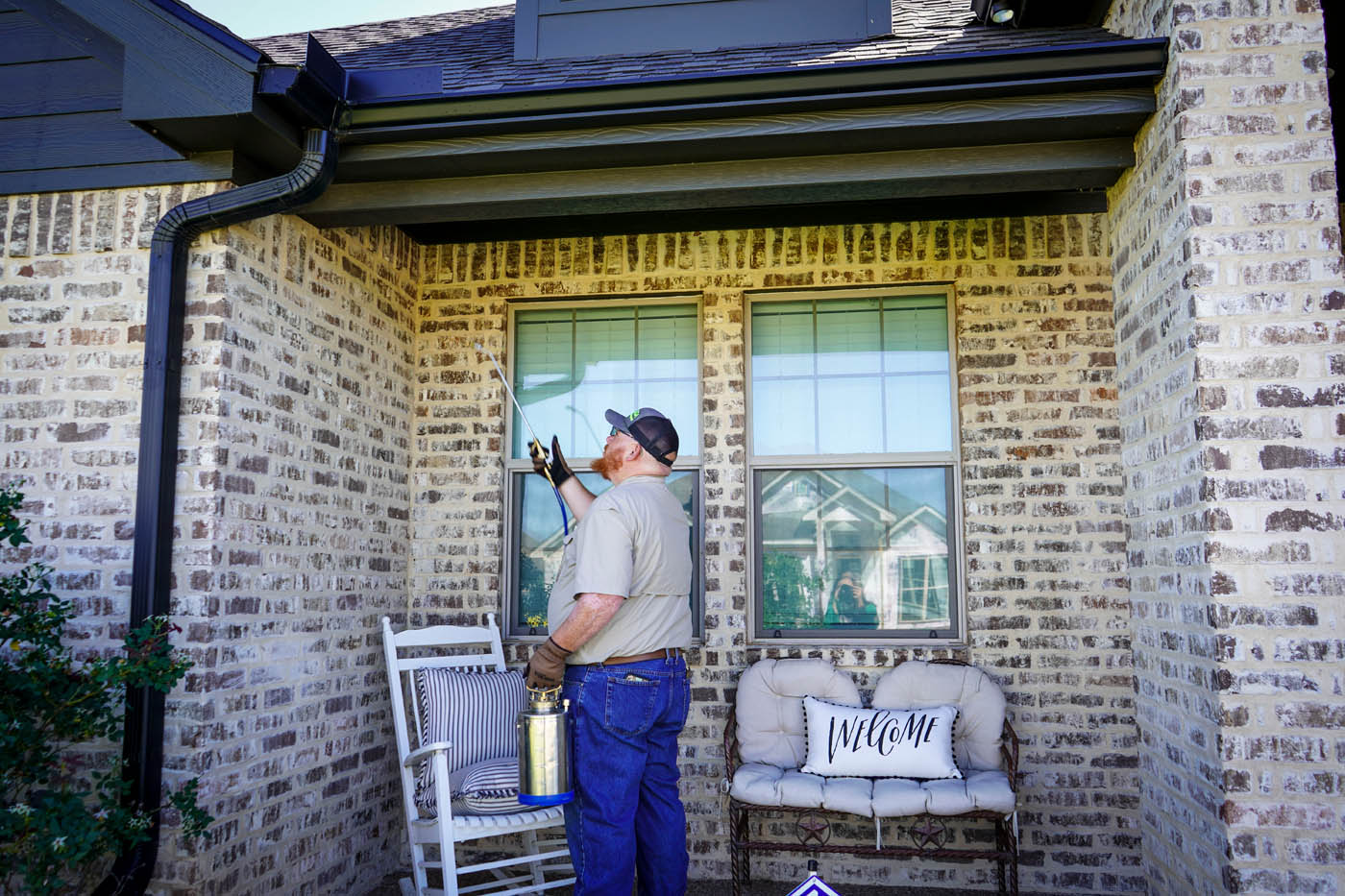 A GGA Pest Management Temple, TX technician looking at the windows to a home.