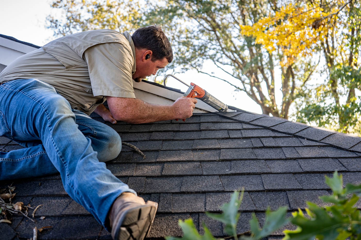 A GGA Pest Management technician caulking a roof.