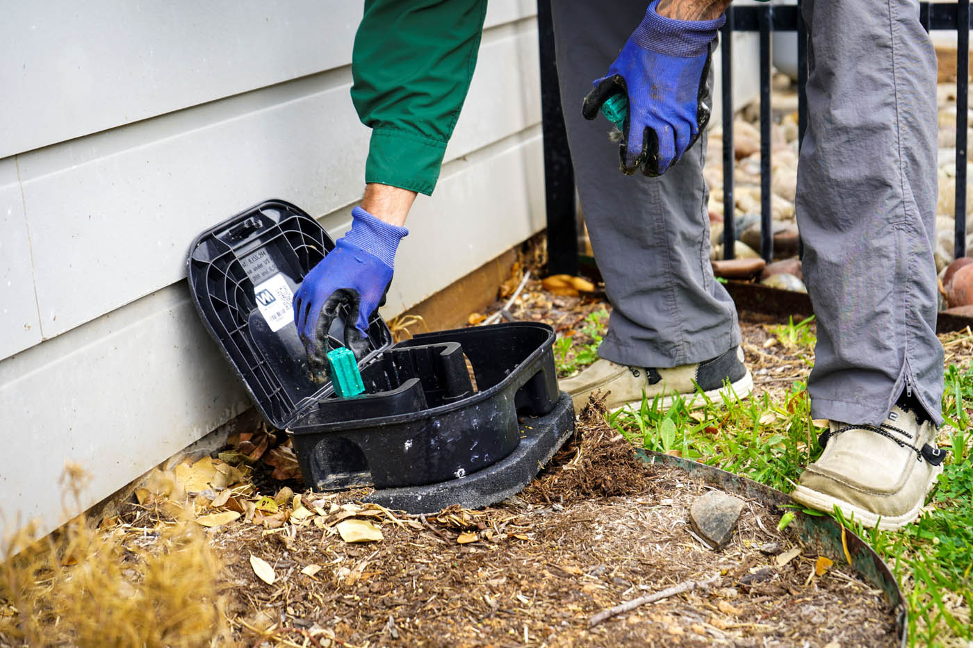 A GGA technician performing Hillsboro pest management services with a trap box.