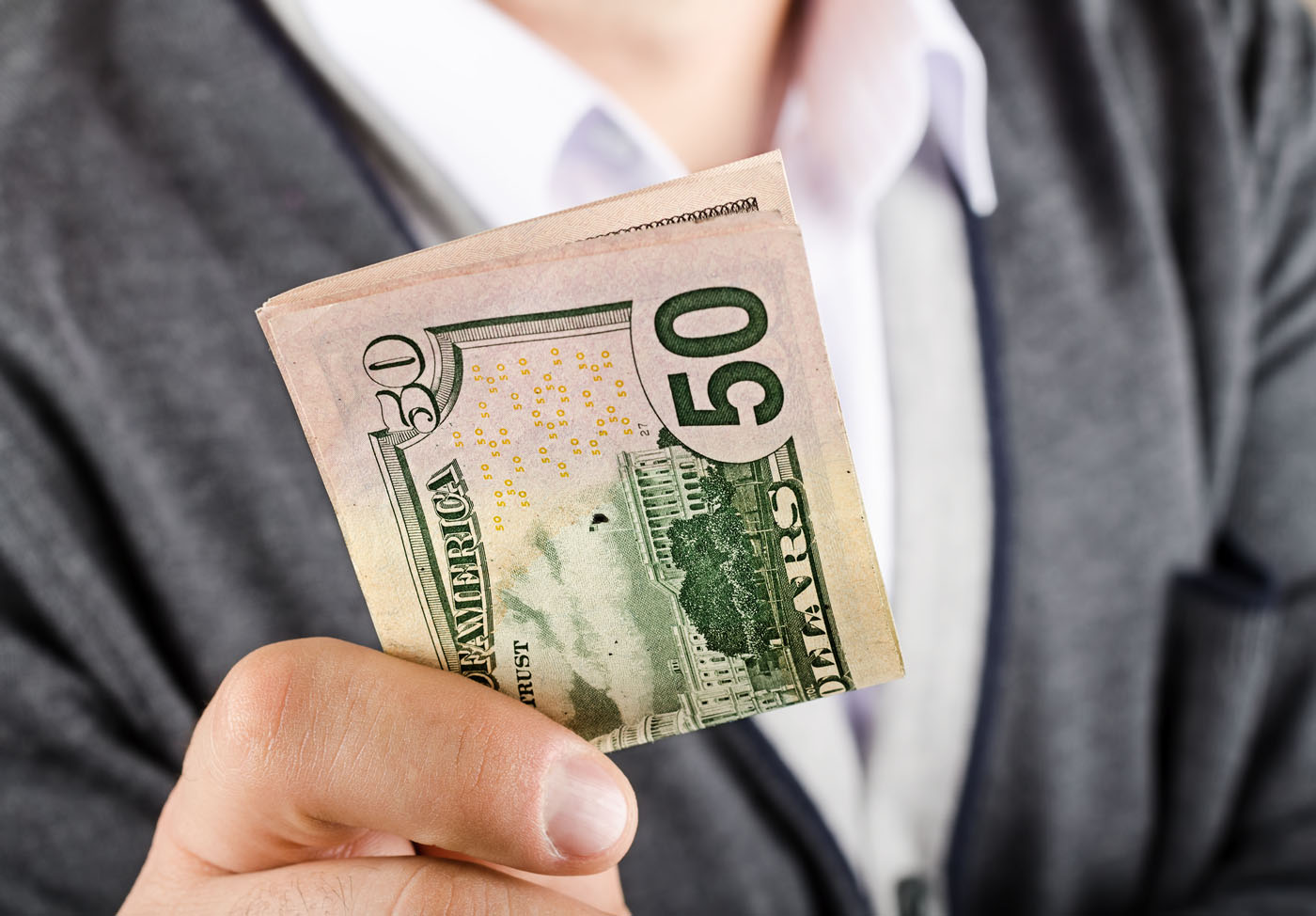 An image of a person holding money in their hands - learn about our customer referral offerings in Killeen, TX and how you can earn rewards from GGA Pest Management.