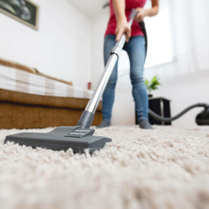 Young woman using vacuum cleaner to clean the house